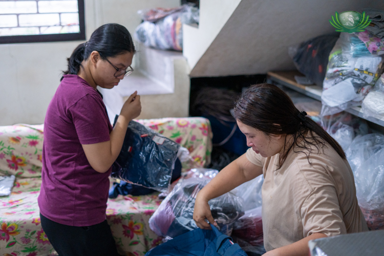 Faith Edrianne Manalastas (left) helps her mother Annaricca arrange clothes for selling.