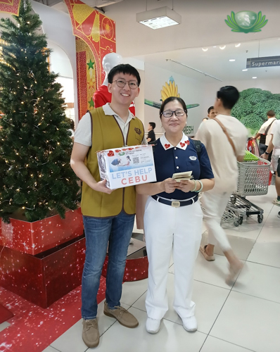 Standing at the entrance of Metro Department Store with volunteer Anna Wu, Paulo Aquino (left) says his first volunteering experience with Tzu Chi was fun and different. “I got to talk to random people and help others.” 