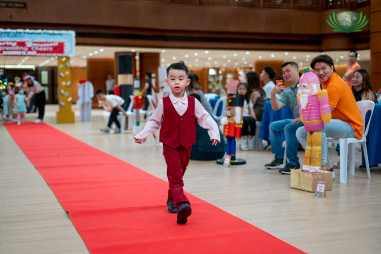 Pre-kindergarten students waved and smiled as they paraded along the red carpet.