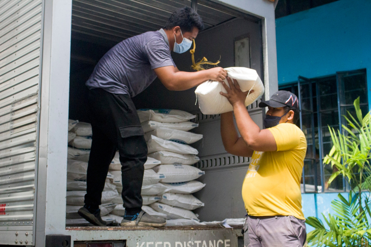 A Tzu Chi volunteer unloads a sack of rice for Tahanang Walang Hagdanan. 【Photo by Matt Serrano】