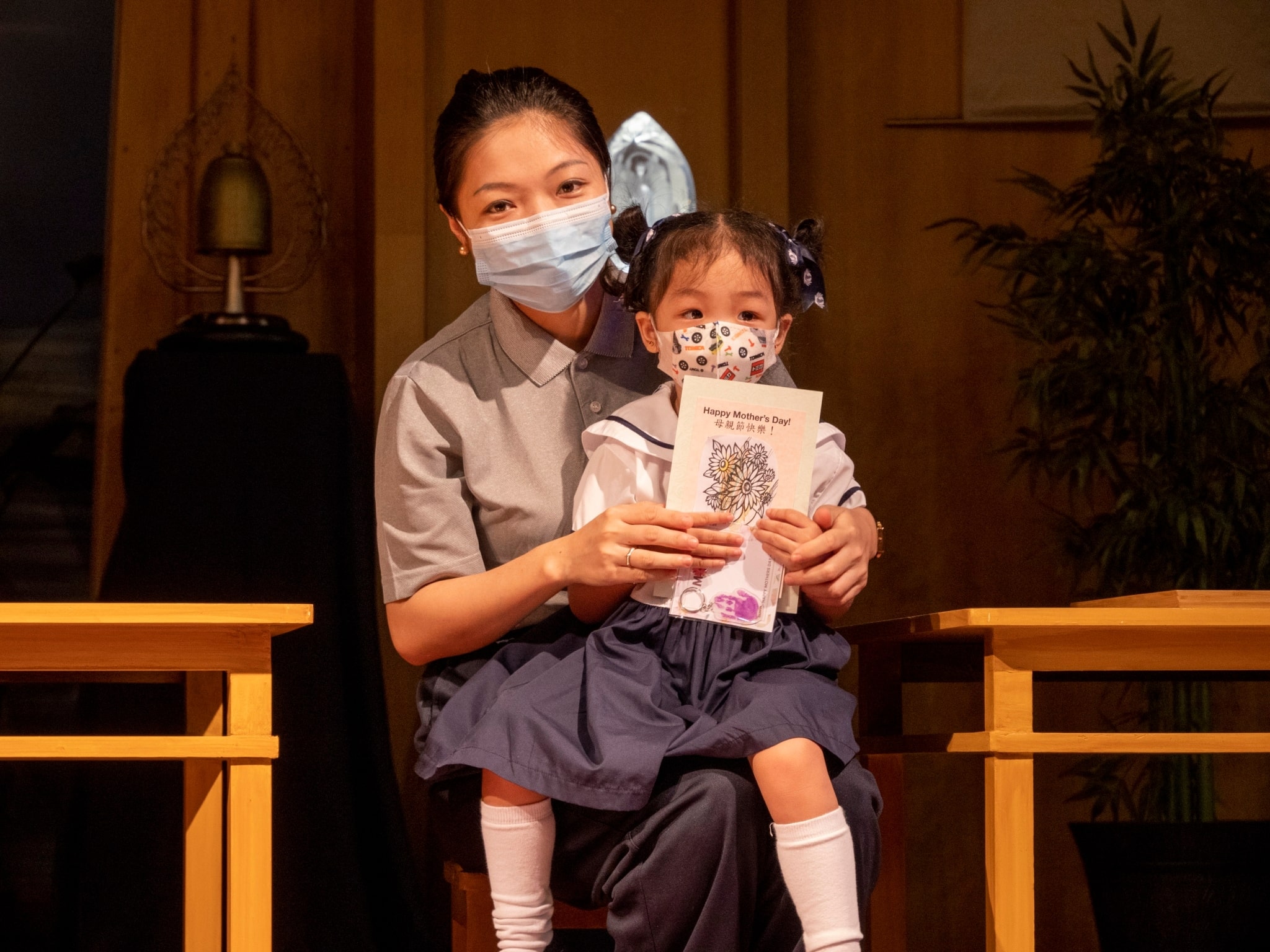 Preschool students invite their mothers to the stage and present them with flowers, cards, and a back massage. 【Photo by Matt Serrano】