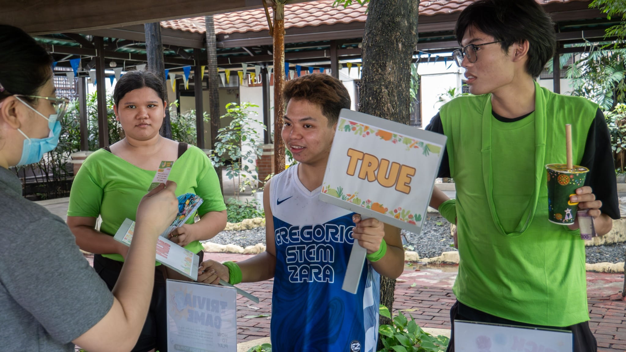 Louie Eriphyel Valle (center) listens as a Tzu Chi volunteer reads a statement in a trivia game. 