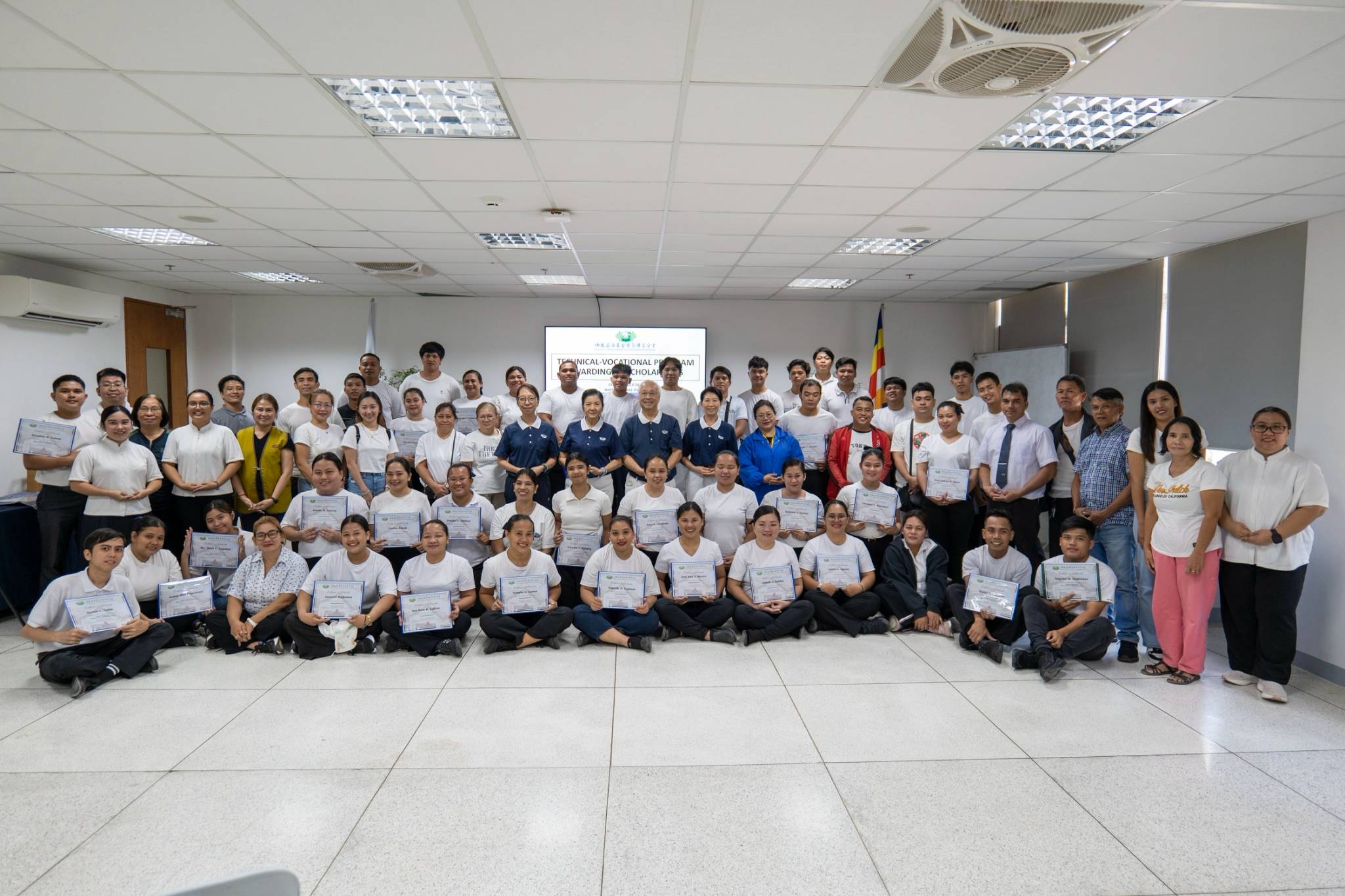Bringing the inspiring day to a joyful close, new scholars, guardians, volunteers, and staffers gather together for a commemorative group photo to celebrate the success of the scholarship awarding ceremony.