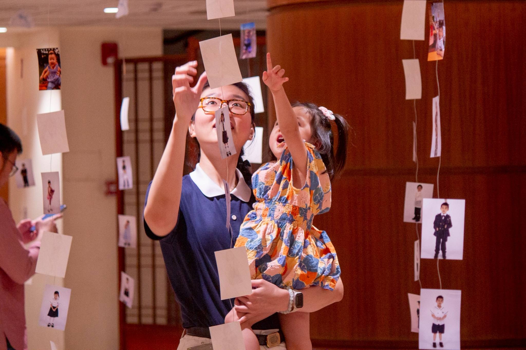 Tzu Chi volunteer check out photos of the students strung from the ceiling.