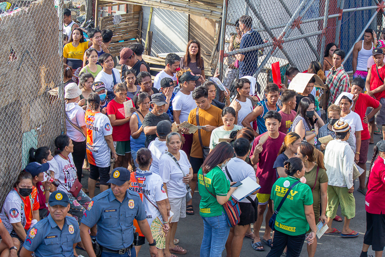 On April 22, the representatives of families whose homes were affected by the fire line up with their claim stubs on hand as they wait for their turn to receive the GI sheets. 【Photo by Marella Saldonido】