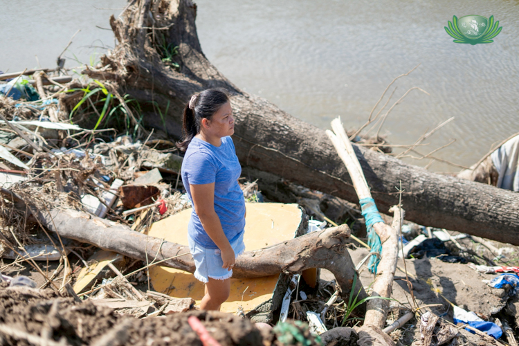 Ana Marie Sacudit, 42, of Brgy. Roberto S. Benedicto, La Carlota, stands before the site where her house once stood. She is still overwhelmed by the weight of loss.