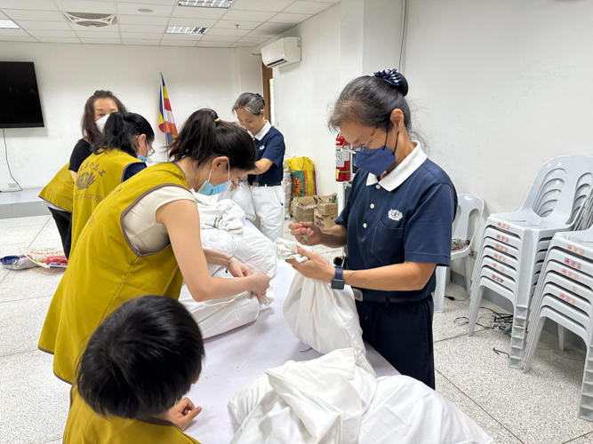 Volunteers neatly secure sets of clothes ready for distribution.