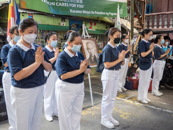 Tzu Chi volunteers lead the prayer during the relief operations in Barangay 598, Sta Mesa, Manila. 【Photo by Matt Serrano】