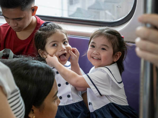 Playful moments between preschoolers highlight the joy of shared experiences during the LRT journey.