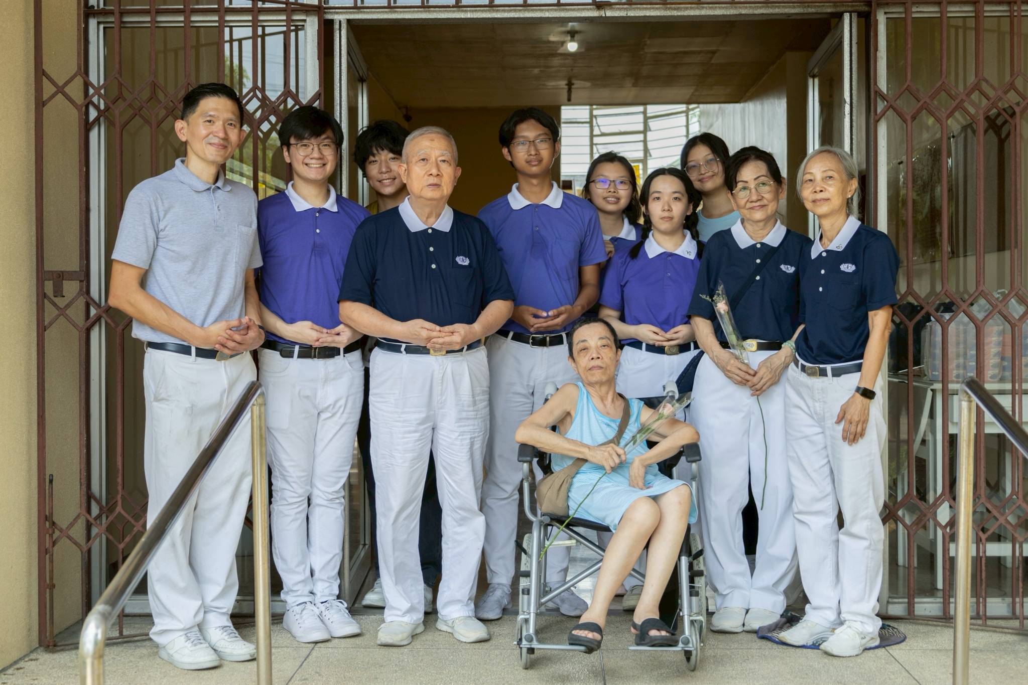 Tzu Chi volunteers and youth pose together with medical beneficiary Perla Tan, after successfully assisting her transfer to her new home. 