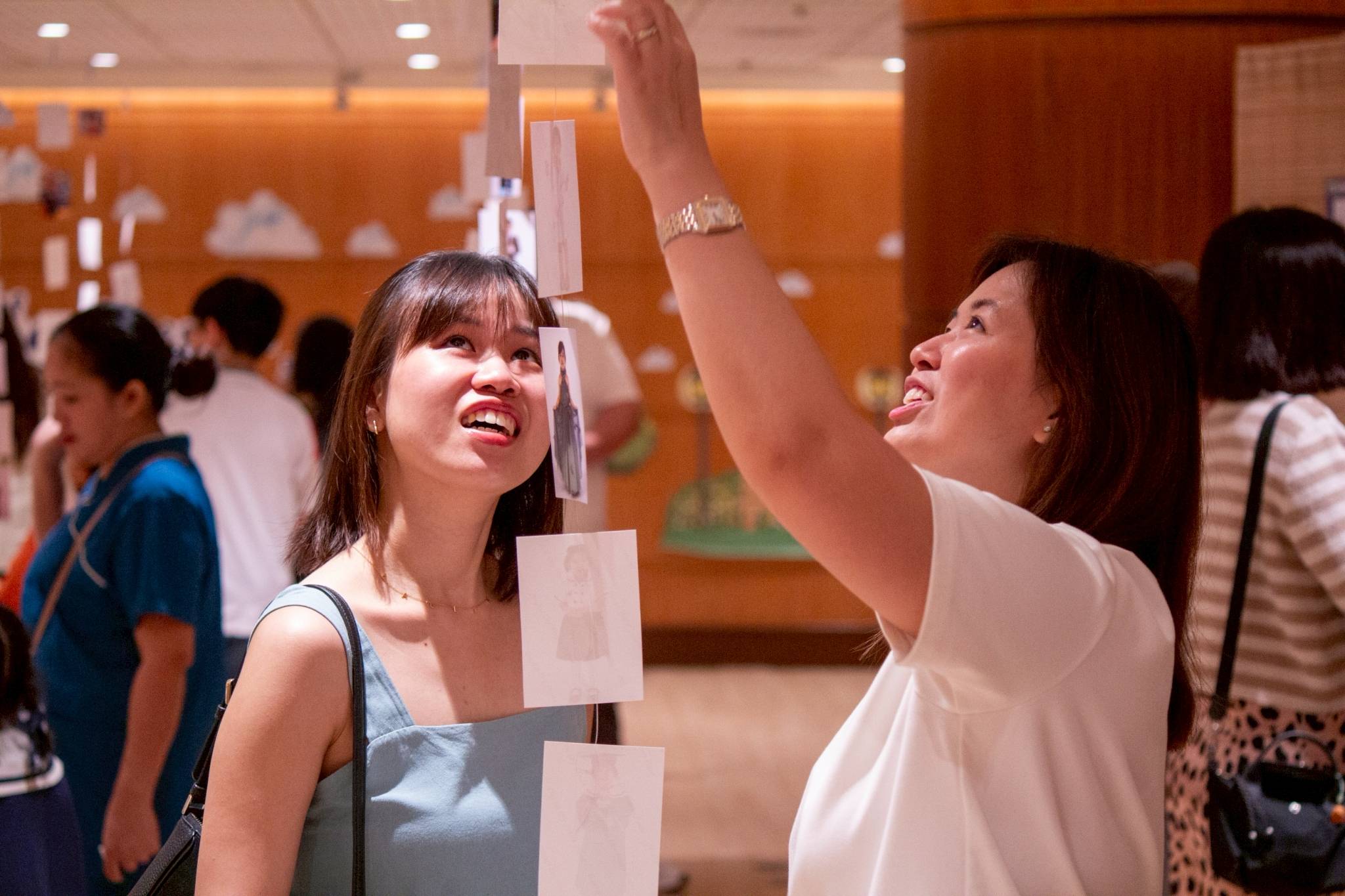 Guests check out photos of the students strung from the ceiling.