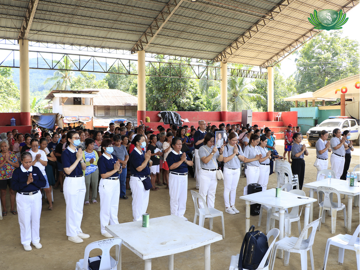 Tzu Chi volunteers lead beneficiaries in prayer.