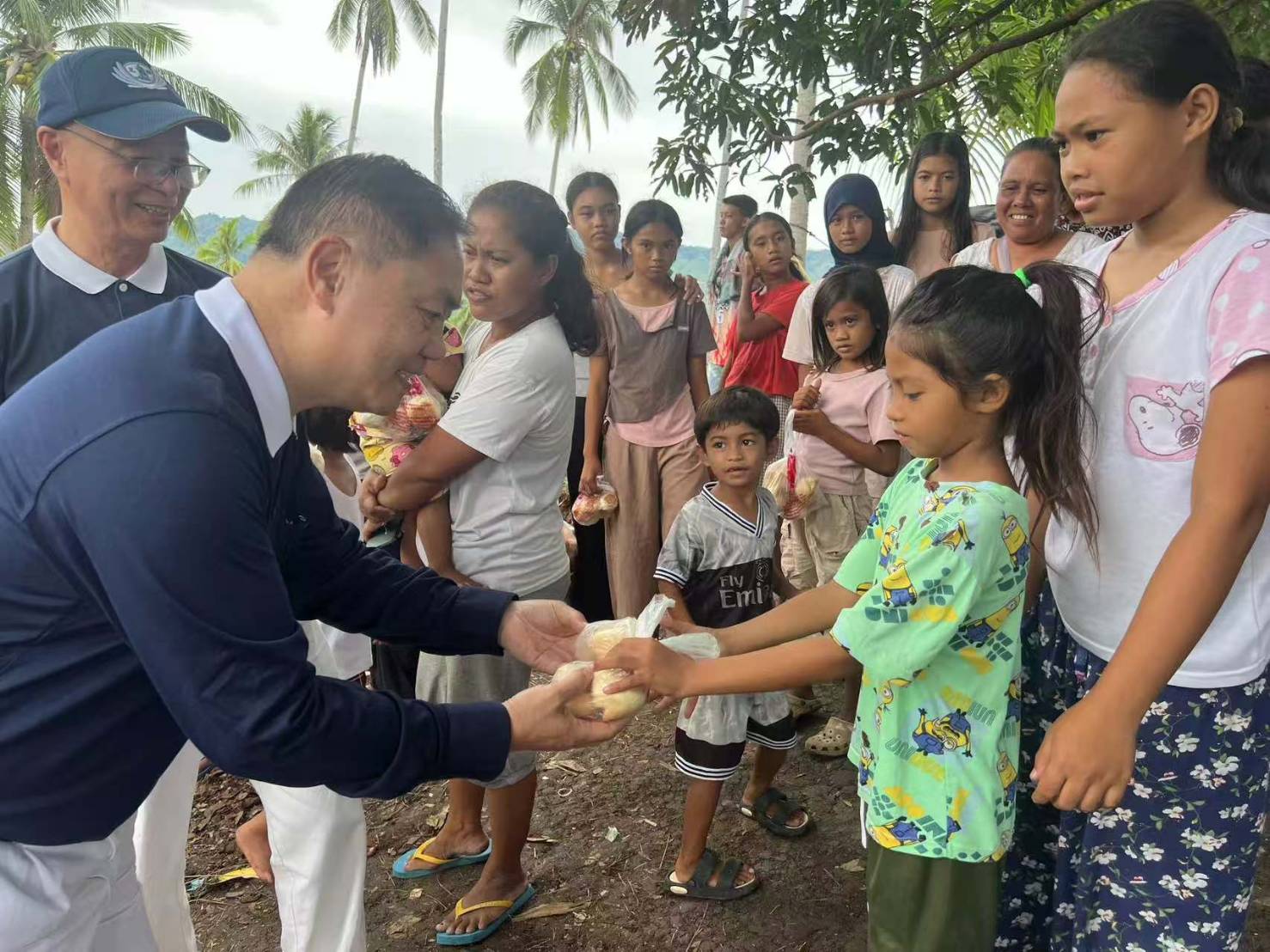 A little girl receives bread from Tzu Chi volunteer Peter Uy.