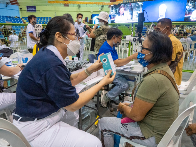 Patients sample reading glasses with the help of a Tzu Chi volunteer. 【Photo by Matt Serrano】