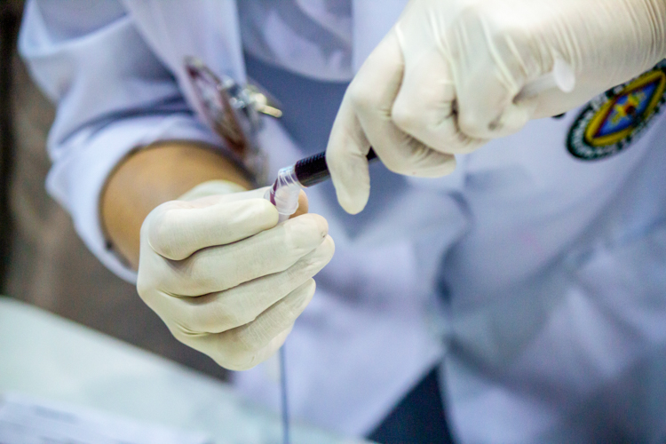 A MedTech student from Sultan Kudarat State University transfers the blood sample for the laboratory tests. 【Photo by Marella Saldonido】