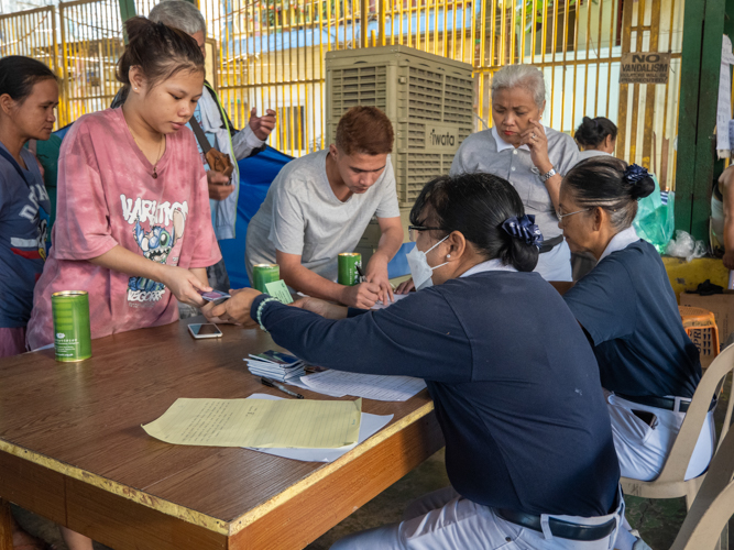 Representatives of families affected by the fire line up to get their claim stubs. 【Photo by Matt Serrano】