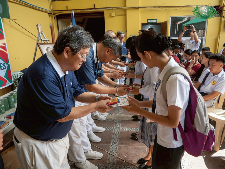 Volunteers distribute Tzu Chi materials to student beneficiaries.