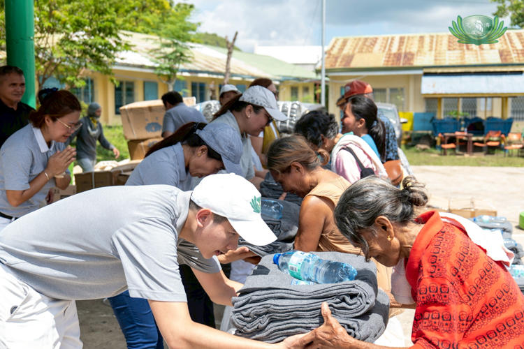 With a bow of gratitude, beneficiaries receive their relief from volunteers.