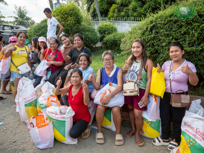 Residents from barangays Biasong, Dumlog, and Lawaan pose outside Sisters of Mary Girlstown as they wait to have their 25-kg rice sacks loaded.