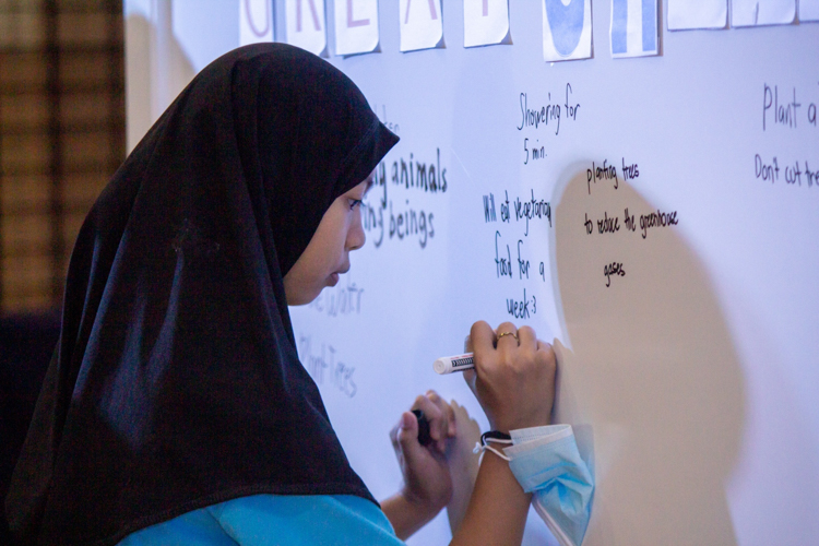 Tzu Chi scholars approach the white board to write the acts of kindness they can commit to. 【Photo by Marella Saldonido】