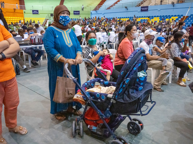 Meriam Zacaria Sangki waits for her turn to receive Raihan’s medicine at the pharmacy area. 【Photo by Matt Serrano】