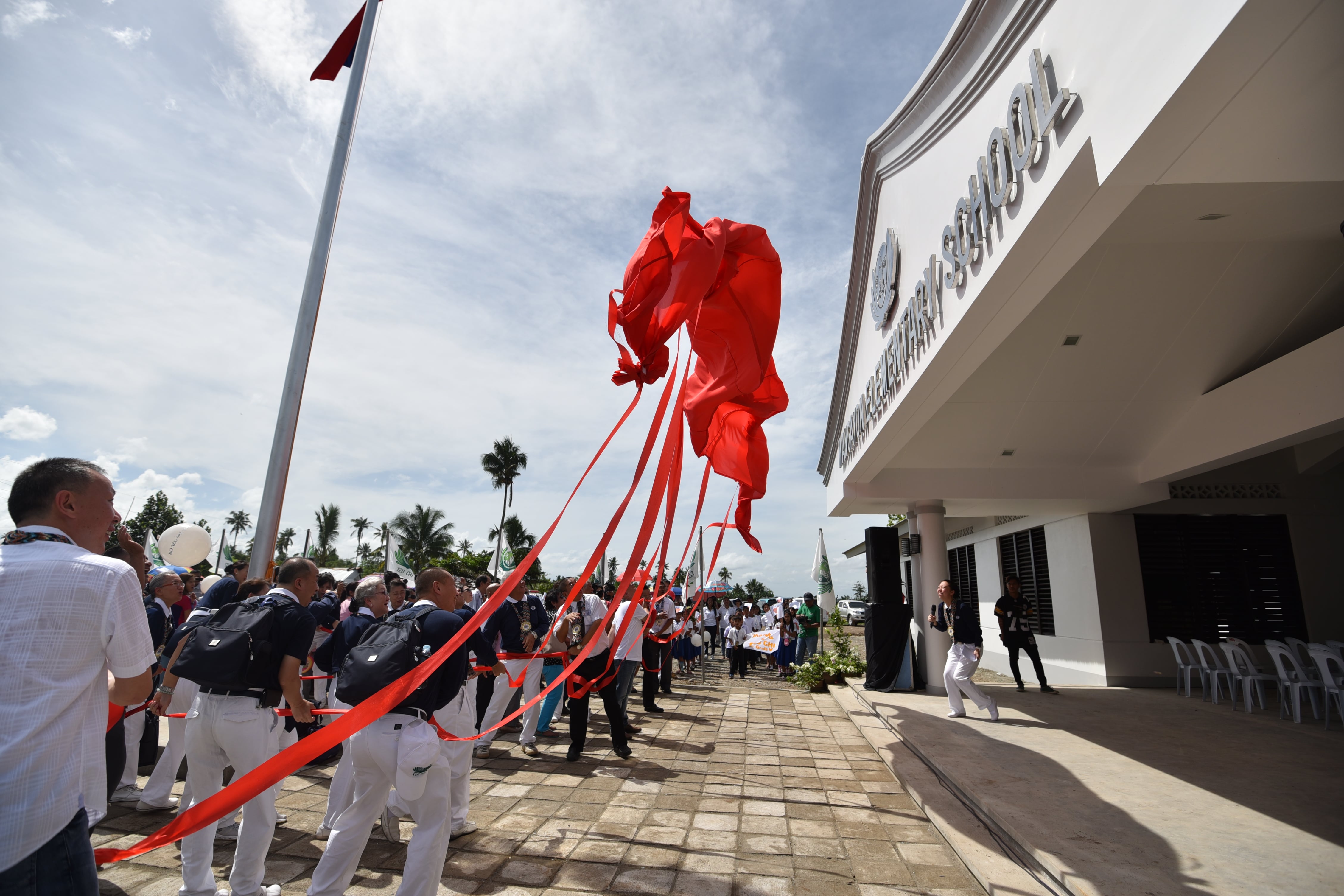 Tzu Chi volunteers participate in the symbolic unveiling of the new Mangayon Elementary School. Destroyed beyond repair following Super Typhoon Pablo in 2012, the school was rebuilt beginning in November 2013 and turned over on December 1, 2014.