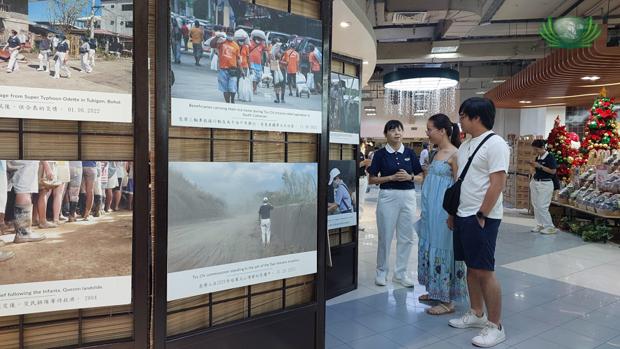 A mini photo exhibit featuring Tzu Chi Foundation’s relief work in the Philippines allows volunteers to explain to shoppers where their donations go. 