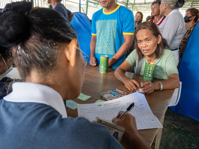 Representatives of families affected by the fire line up to get their claim stubs. 【Photo by Matt Serrano】