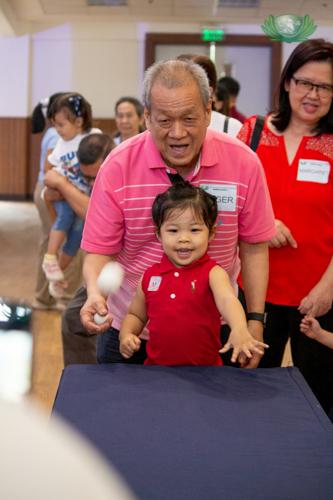 This grandfather-granddaughter duo happily take part in the egg carton pingpong game.