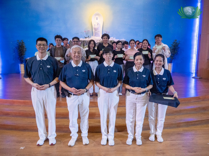Taiwanese volunteers join Tzu Chi Foundation Philippines CEO Henry Yuñez (second from left), Tzu Chi Education Committee Head Rosa So, and Tzu Chi volunteer Jinny Ong (fourth and fifth from left) in awarding scholars who graduated with Latin honors.