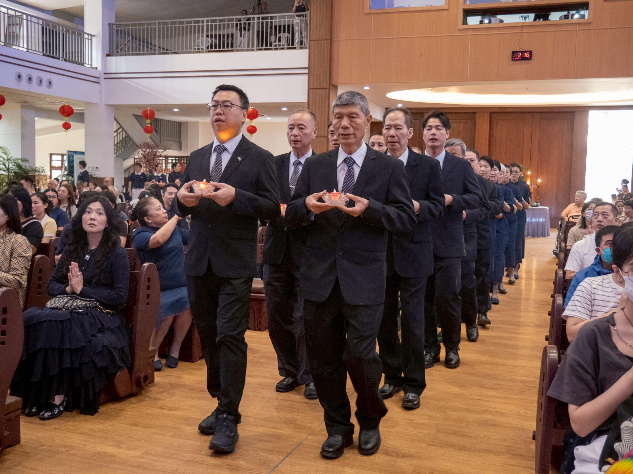 The Year End Blessing’s afternoon program began with a solemn procession of volunteers offering candles and fruits to Buddha. 