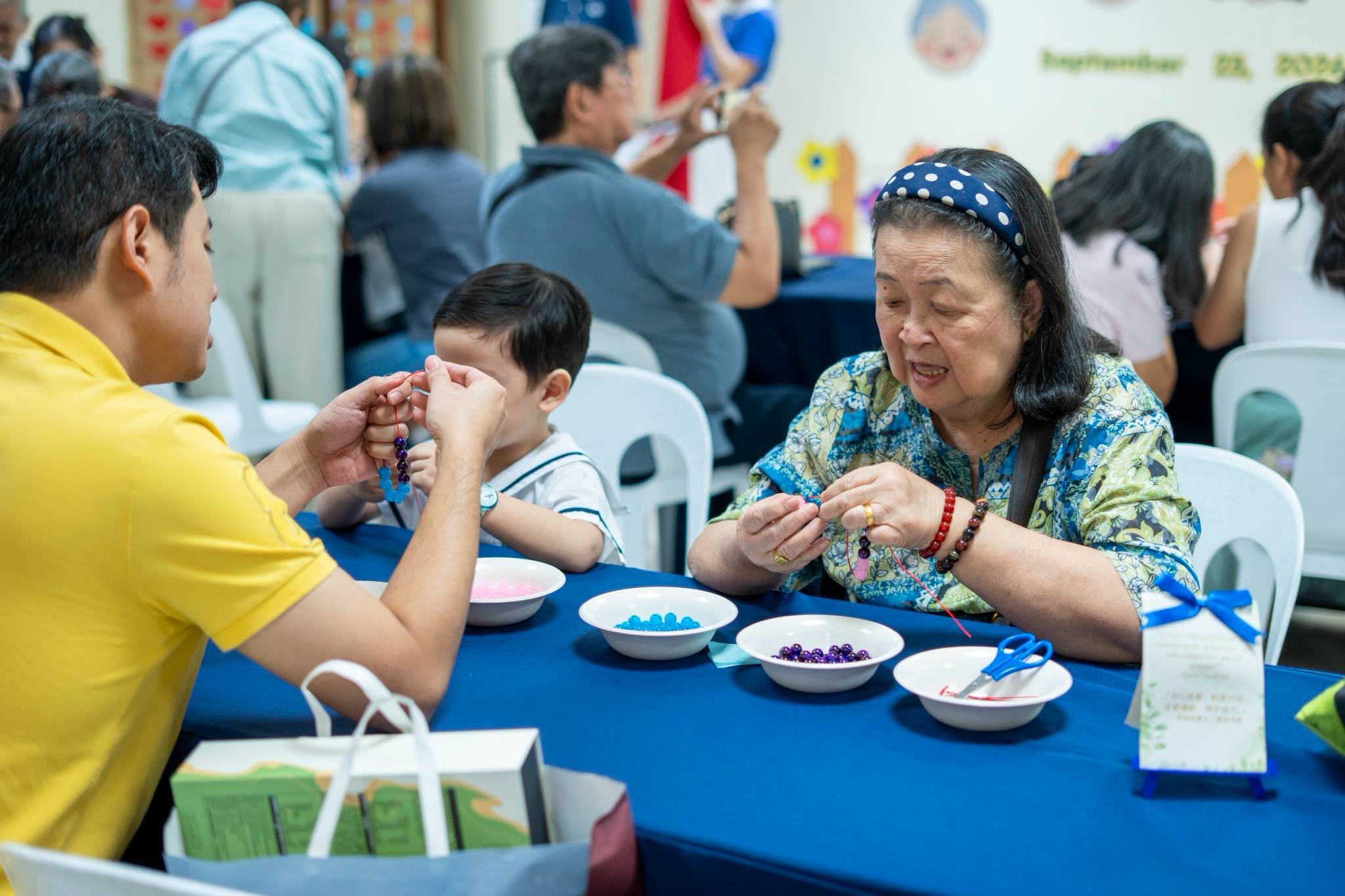 Grandparents string beads together to make a bracelet. 