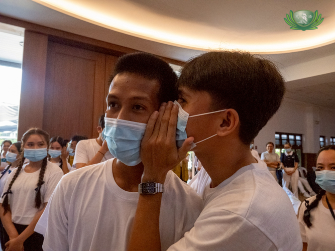 A scholar whispers an aphorism from Master Cheng Yen to a fellow scholar in a game held at the Jing Si Auditorium. 