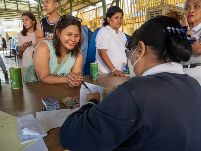 Representatives of families affected by the fire line up to get their claim stubs. 【Photo by Matt Serrano】