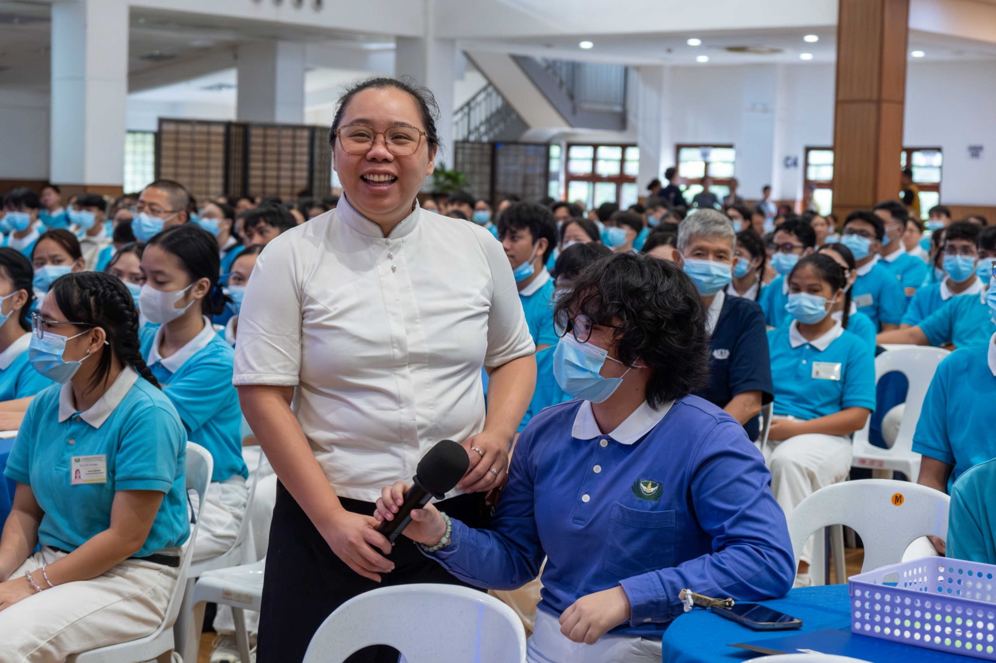 Tzu Chi volunteer Cherrie Rose Ang provides a member of Tzu Chi Youth with a mic during a Q&A portion.