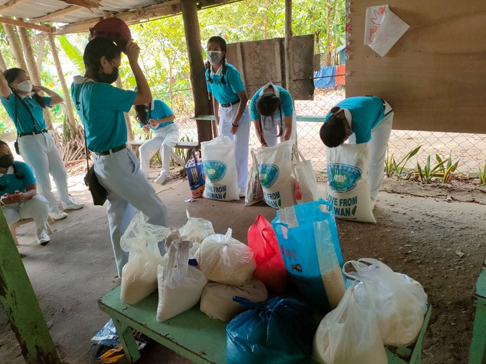 Tzu Chi scholars from Catmon repack rice they received into 3-kg packs. Twenty-seven packs were then distributed to families in coastal barangays who suffered greatly from the storm.