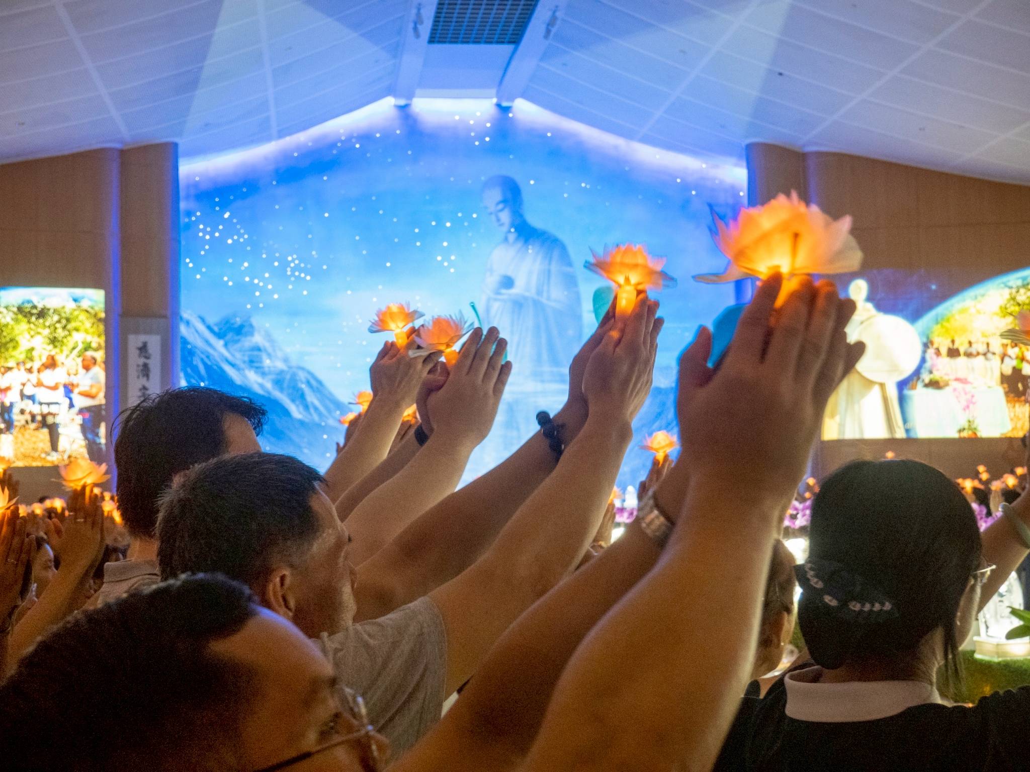 The act of raising lotus candles reflects devotion to the Buddha and a unified hope for purity in hearts, harmony in society, and a disaster-free world.
