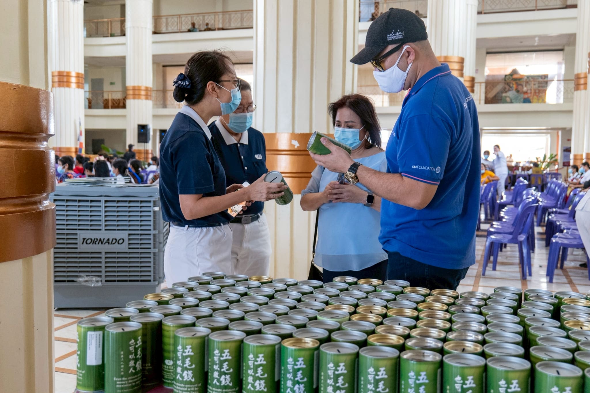(From left) Tzu Chi Deputy CEO Peggy Sy Jiang and Tzu Chi Department of Communications Head Judy Lao explain the relevance of the coin bank to SM Foundation, Inc. Executive Director for Health and Medical Programs Connie Angeles and SM Foundation, Inc. Senior Project Manager for Health and Medical Programs Albert Uy.