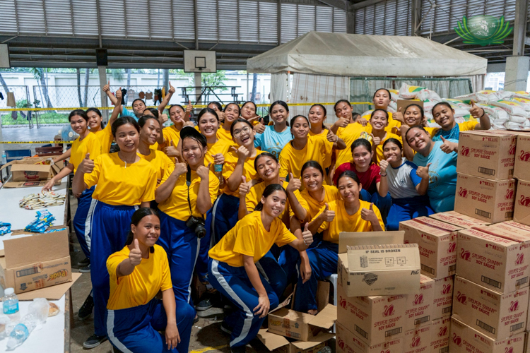 Sisters of Mary student volunteers smile after helping with crowd control at the relief distribution.