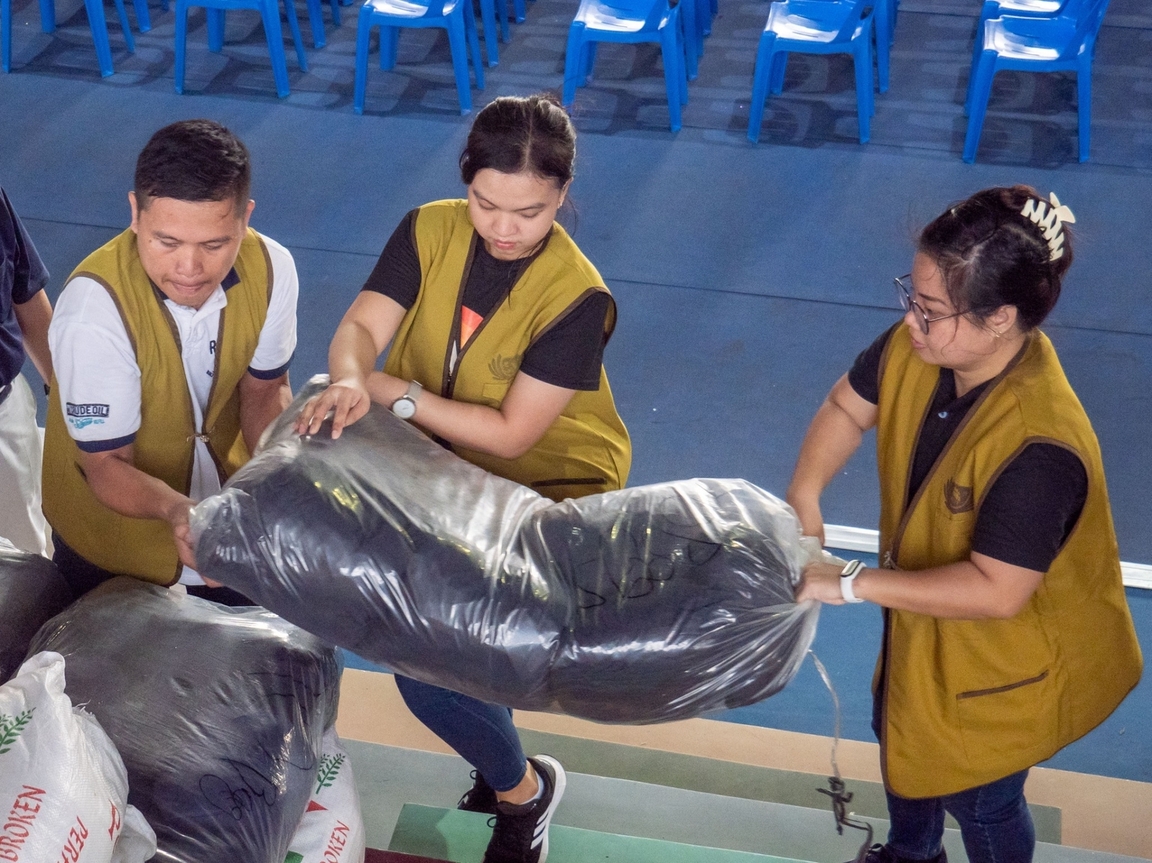 Tzu Chi volunteers help one another in carrying the sacks of relief goods for beneficiaries. 