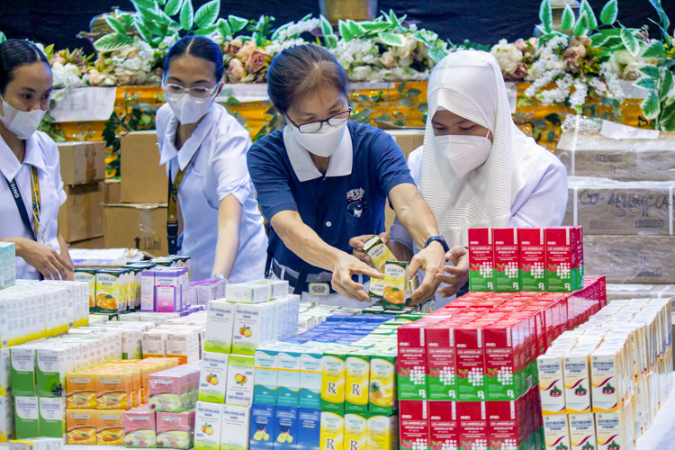 Tzu Chi volunteer Elvira Chua helps the student nurses check the medications at the pharmacy area. 【Photo by Marella Saldonido】