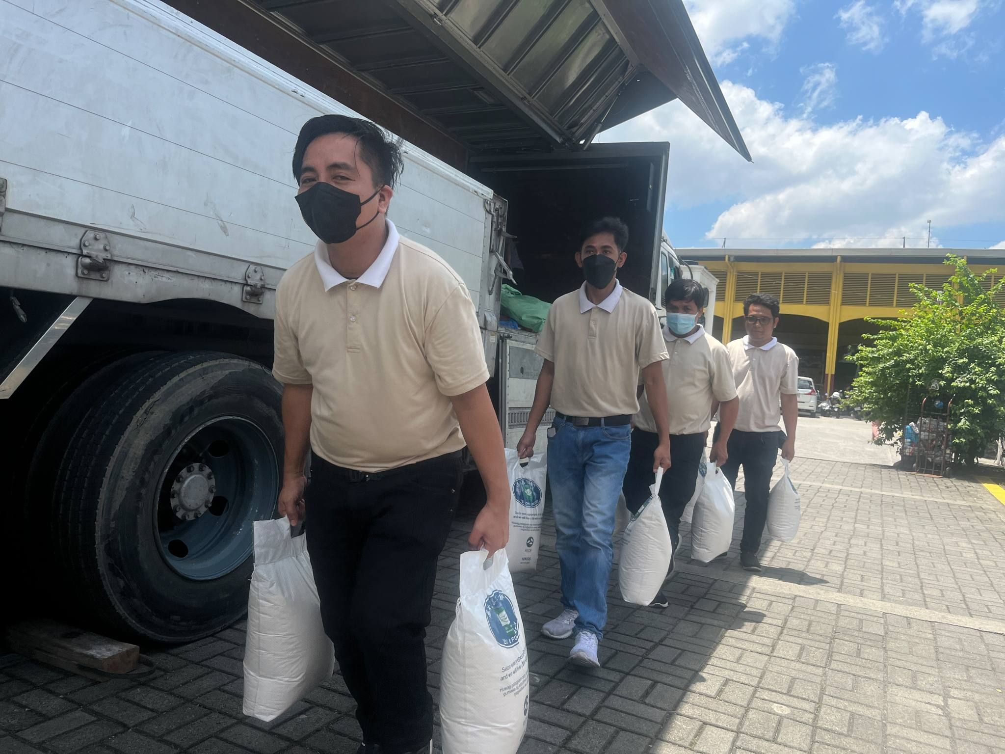 Tzu Chi Technical-Vocational scholars help bring sacks of 10kg rice donated to San Pablo Apostol Parish, the relief venue, for their upcoming feeding program.