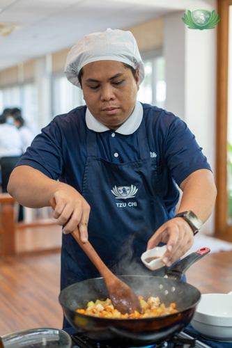 Following volunteer Wilfredo Ortiz Jr.’s instructions, scholars peel and chop ingredients for a vegetarian menudo. 