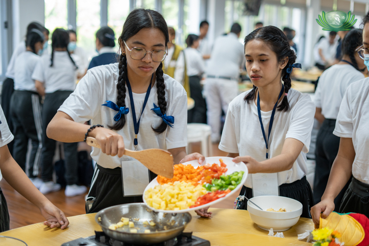 Following volunteer Wilfredo Ortiz Jr.’s instructions, scholars peel and chop ingredients for a vegetarian menudo. 