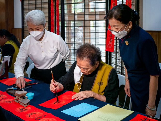 A calligrapher executes messages of hope and good thoughts in Chinese characters. 【Photo by Daniel Lazar】