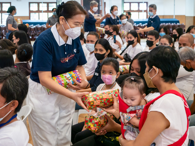 Volunteer Ligaya Ng helps distribute Christmas gifts to medical assistance beneficiaries. 【Photo by Daniel Lazar】