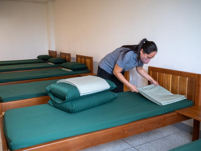 A volunteer prepares beddings for scholars at the Harmony Hall.【Photo by Matt Serrano】