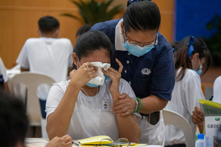 A volunteer comforts a scholar who was moved to tears by Albert Briongos’ talk on filial piety. 【Photo by Matt Serrano】