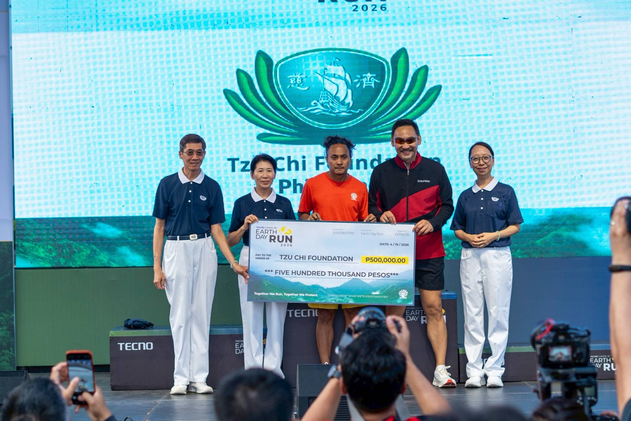 (From left) Tzu Chi volunteer Johnny Cheng, Tzu Chi Deputy CEO Woon Ng, Runrio Inc. race director Coach Rio de la Cruz, Runrio Inc. general manager Andrew Neri, and Tzu Chi Deputy CEO Peggy Sy Jiang pose with a P500,000 check from the Earth Day Run race organizer to its advocacy partner since 2024. 