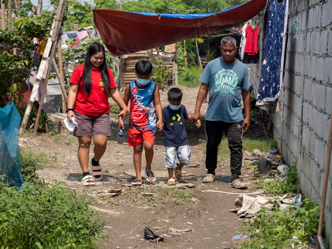 The Telecio family walk to their new humble home beside the housing estate at Panghulo, Malabon.